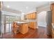 Open kitchen with stainless steel appliances, island with bar seating, and hardwood floors at 1330 Badingham Dr, Cumming, GA 30041