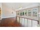 Sunlit living room boasts large windows, ceiling fan, and rich hardwood flooring at 1330 Badingham Dr, Cumming, GA 30041