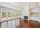 Bright living room with fireplace, built-ins, large windows, and dark hardwood floors at 1330 Badingham Dr, Cumming, GA 30041