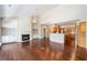 Open-concept living area with fireplace, kitchen, hardwood flooring, and bright lighting at 1330 Badingham Dr, Cumming, GA 30041