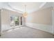 Bright living room featuring a chandelier, crown molding, and large windows at 1330 Badingham Dr, Cumming, GA 30041