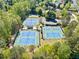 Aerial view of community tennis courts featuring well-maintained blue courts and surrounding trees and landscaping at 1330 Badingham Dr, Cumming, GA 30041
