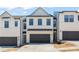 Modern townhome featuring a two-car garage and a stylish, symmetrical facade at 1028 Sutherland Lane (Lot 45), Lawrenceville, GA 30043