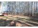 Expansive grassy backyard featuring a spacious deck and mature trees providing ample shade and privacy at 4557 Waldens Farm Ct, Powder Springs, GA 30127