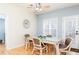 Light-filled dining area with a glass table, seating for four, and a door leading outside at 4557 Waldens Farm Ct, Powder Springs, GA 30127