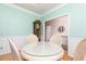 Intimate dining area view with hardwood floors, chandelier, and a charming grandfather clock visible beyond at 4557 Waldens Farm Ct, Powder Springs, GA 30127