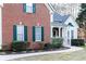 Close-up of the house's brick facade, green shutters, and manicured bushes along a curved walkway at 4557 Waldens Farm Ct, Powder Springs, GA 30127