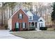 Traditional home featuring brick and vinyl siding, attached garage, and well-manicured lawn on a treed lot at 4557 Waldens Farm Ct, Powder Springs, GA 30127