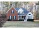 Charming two-story home with brick facade, covered porch, and lush landscaping creating great curb appeal at 4557 Waldens Farm Ct, Powder Springs, GA 30127