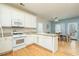 Well-lit kitchen with a breakfast bar, white cabinetry, and views of the dining area at 4557 Waldens Farm Ct, Powder Springs, GA 30127