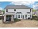 White home's exterior with patio, outdoor kitchen, and landscaped backyard, perfect for entertaining at 6060 Country Lake Rd, Cumming, GA 30041