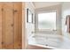 Bright bathroom features a soaking tub, a glass walk-in shower, and frosted windows for privacy at 6060 Country Lake Rd, Cumming, GA 30041