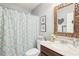 Well-lit bathroom features a decorative shower curtain, marble countertop, and large decorative mirror at 6060 Country Lake Rd, Cumming, GA 30041