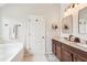Bright bathroom features double vanity with granite counters, soaking tub, and decorative mirrors at 6060 Country Lake Rd, Cumming, GA 30041