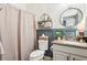 Stylish bathroom featuring a unique round mirror, granite countertop, and patterned wallpaper at 6060 Country Lake Rd, Cumming, GA 30041