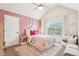 Bright bedroom featuring pink accent wall, large window and area rug at 6060 Country Lake Rd, Cumming, GA 30041