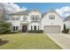 Beautiful two-story home with manicured lawn, front shrubs, and a two-car garage at 6060 Country Lake Rd, Cumming, GA 30041