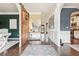 Inviting foyer with hardwood floors, decorative rug, and a view of the office and kitchen at 6060 Country Lake Rd, Cumming, GA 30041