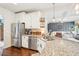 Open kitchen with stainless steel appliances, a granite countertop island, and views of the living room at 6060 Country Lake Rd, Cumming, GA 30041