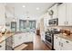 Bright kitchen featuring granite countertops, stainless steel appliances, and an open layout to the living area at 6060 Country Lake Rd, Cumming, GA 30041