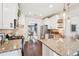 Kitchen showcasing stainless steel appliances, granite countertops, white cabinetry, and dark hardwood floors at 6060 Country Lake Rd, Cumming, GA 30041