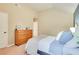 Bright and airy main bedroom with a cozy bed, a wooden dresser, and neutral wall colors at 6060 Country Lake Rd, Cumming, GA 30041