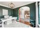 Office with dark green walls, light-colored furniture, and an arched doorway leading to the dining area at 6060 Country Lake Rd, Cumming, GA 30041