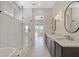Modern bathroom with a glass shower, tub, dual mirrors, and abundant natural light at 1130 Lupo Loop, Chattahoochee Hills, GA 30268