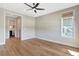 A spacious bedroom with hardwood floors, ceiling fan, large window and en suite bathroom access at 1130 Lupo Loop, Chattahoochee Hills, GA 30268