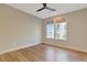 Bedroom with hardwood flooring, neutral paint, and a modern ceiling fan with natural light at 1130 Lupo Loop, Chattahoochee Hills, GA 30268