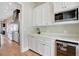 Butler's pantry with white cabinets, granite countertops, and a wine cooler at 1130 Lupo Loop, Chattahoochee Hills, GA 30268
