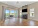 Bright living room with fireplace, hardwood floors, and sliding doors to a balcony at 1130 Lupo Loop, Chattahoochee Hills, GA 30268