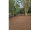 Spacious backyard with tall trees and a rustic wooden fence, covered with fresh pine straw at 2012 Grove Park Ct, Marietta, GA 30062