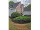 Side view showcasing the house's landscaping, including a mix of bushes and fresh mulch at 2012 Grove Park Ct, Marietta, GA 30062