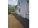 Well-kept yard with mulch landscaping, showcasing the home's siding and a small window at 2012 Grove Park Ct, Marietta, GA 30062
