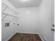 An efficient laundry room with wooden floors, utility sink, and overhead shelving at 4166 Rue Saint Michel, Stone Mountain, GA 30083
