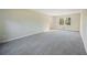 Bright living room with neutral walls, new carpet, a large window, and baseboard trim at 4166 Rue Saint Michel, Stone Mountain, GA 30083