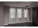 An airy bedroom with a modern chandelier, light-filtering curtains, and dark hardwood floors at 600 Broadview Ne Ter, Atlanta, GA 30324
