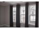 Bedroom showcasing three large windows with elegant gray curtains at 600 Broadview Ne Ter, Atlanta, GA 30324