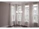 Bright living room with many windows dressed with flowing white drapes, and a dark hardwood floor at 600 Broadview Ne Ter, Atlanta, GA 30324