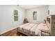 Cozy bedroom with wood-look floors, neutral walls, and natural light from two windows at 3076 Nectar Dr, Powder Springs, GA 30127