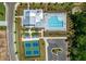 Aerial view of community clubhouse, swimming pool, tennis courts, parking, and manicured green spaces at 5385 Keepsake Court, Cumming, GA 30040
