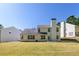 Rear exterior view of a two-story home with a spacious backyard and mature trees at 2181 Poplar Grove Ct, Snellville, GA 30078