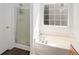 Bright bathroom features a combination shower and tub with white tile at 2181 Poplar Grove Ct, Snellville, GA 30078