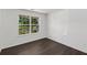 Bright bedroom with a large window offering a view of the surrounding landscape and dark hardwood floors at 2181 Poplar Grove Ct, Snellville, GA 30078