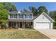 Charming two-story home with a brick facade and attached two car garage and a manicured front yard at 2181 Poplar Grove Ct, Snellville, GA 30078