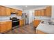 Well-lit kitchen with stainless steel appliances, wood cabinets, and hardwood floors at 2181 Poplar Grove Ct, Snellville, GA 30078