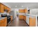 Well-lit kitchen with stainless steel appliances, wood cabinets, white backsplash, and hardwood floors at 2181 Poplar Grove Ct, Snellville, GA 30078