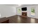 Bright living room features a brick fireplace, modern hardwood floors, and white trim at 2181 Poplar Grove Ct, Snellville, GA 30078
