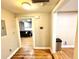 Hallway with hardwood floors, leading to a living room with a black sofa, and bathroom entrance at 635 Sw Queen Sw St, Atlanta, GA 30310